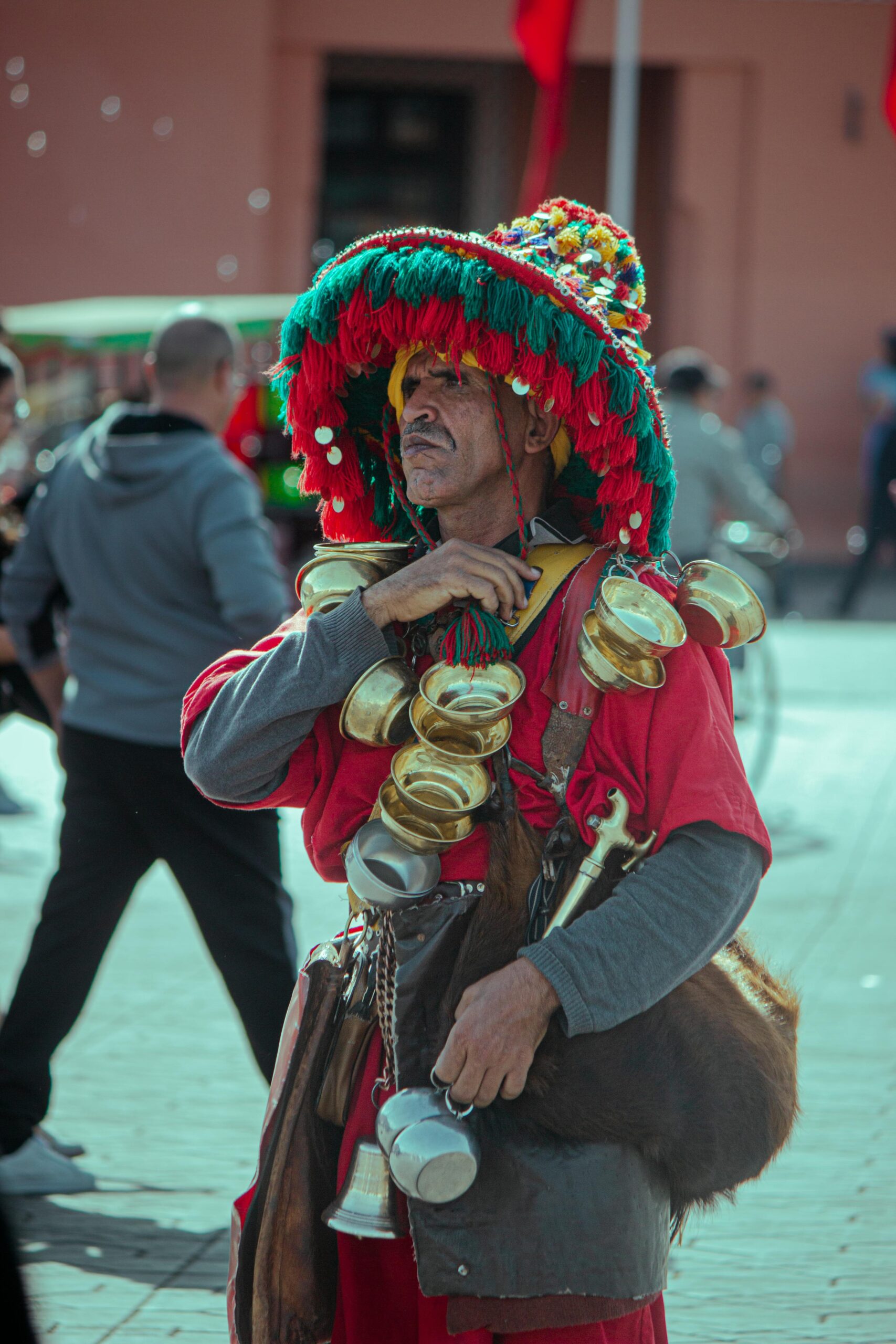 A traditional water seller in vibrant attire in Marrakesh, Morocco, showcasing local culture and street life.