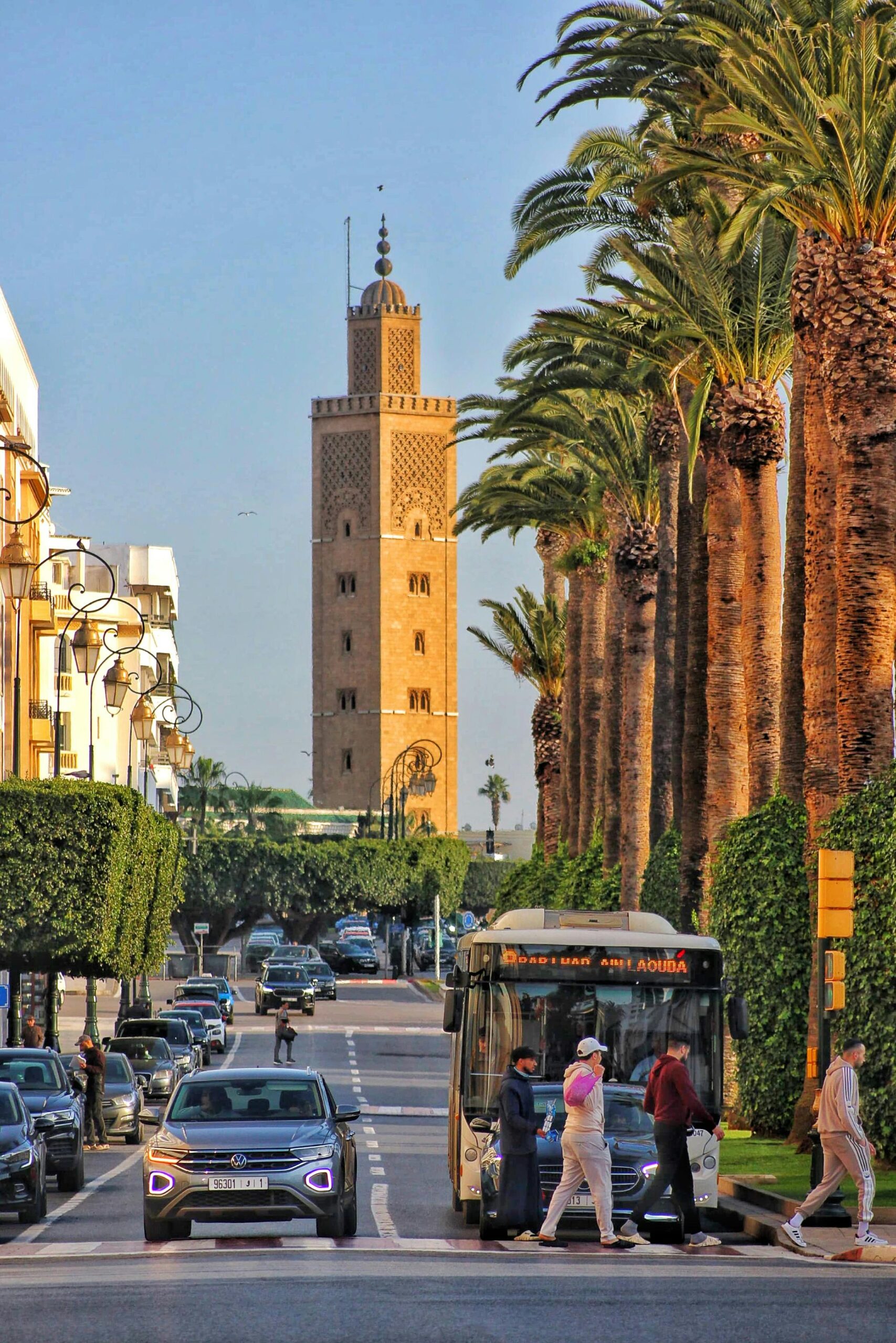 Vibrant city street scene with the Koutoubia Mosque tower in Marrakech, Morocco.